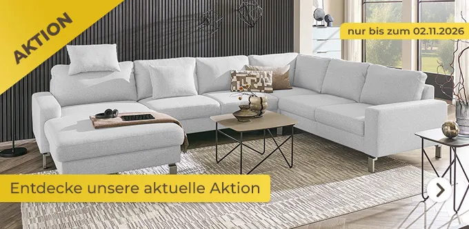 Aktionsbanner: 8% Rabatt auf Wohnlandschaften und Accessoires mit Code "WOAC8". Nur bis zum 02.11.2026. Gezeigt wird das Sofa "Max Schelling Wohnlandschaft Maximum 2.0". Stoff: Flachgewebe. Farbe: Hellgrau. Moderne, heller Wohnraum mit dunklen Holzpaneelen an der Wand, Couchtisch mittig der Wohnlandschaft und rechts am Rand des Bildes, großer, beiger Teppich unter dem Sofa und zwei bodentiefen Fenstern an der rechten Seite.
