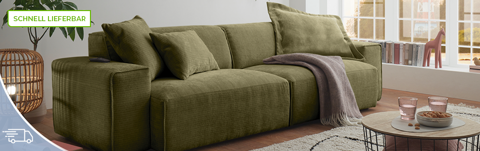 grĂĽnes Sofa, helles Wohnzimmer