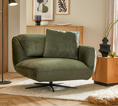 Grüner Sessel im Wohnzimmer mit viel Holz-Optik